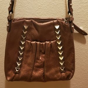A metallic crossbody bag with a long strap.